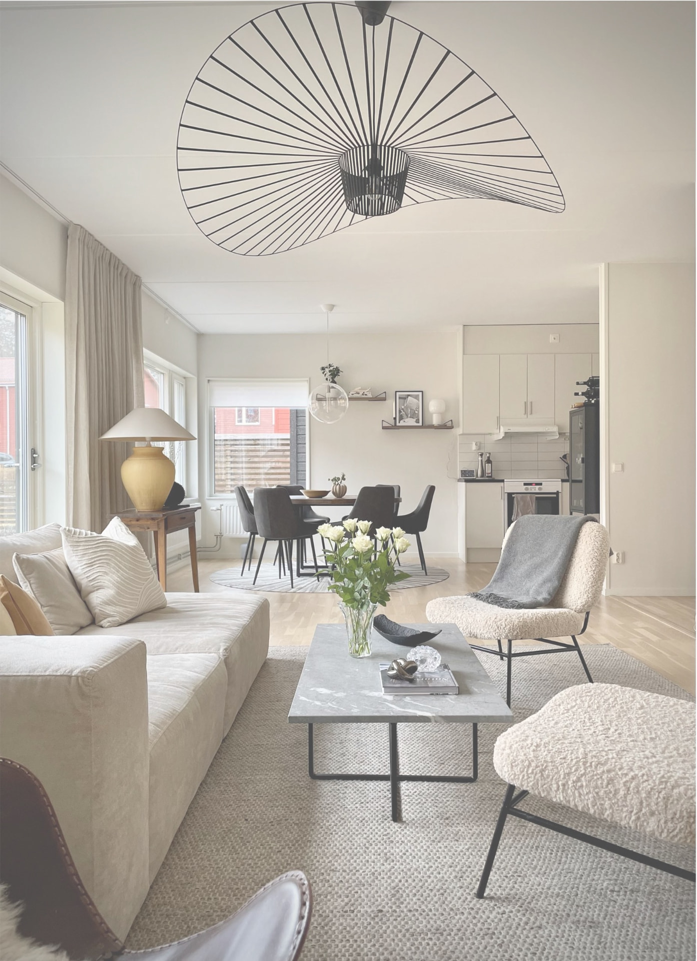 Ljust skandinaviskt vardagsrum med beige soffa, marmorbord och öppen planlösning